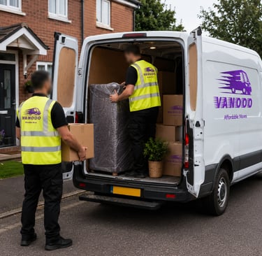 Two professional movers load furniture and boxes into a branded white VANOOO removal van outside