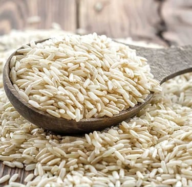 close up of uncooked brown basmati rice in a wooden spoon