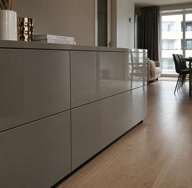 Modern glossy grey storage sideboard on light oak wood flooring in a bright living room.