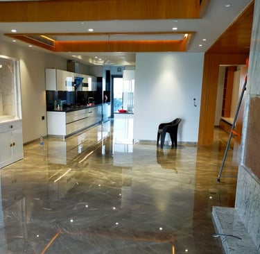 Polished grey marble floor reflecting a modern open-concept kitchen and luxury apartment interior.
