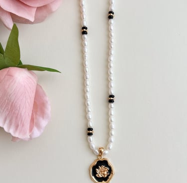 eine natürliche Perlenkette mit einer Blume darauf