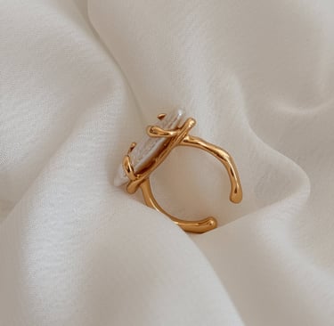 ein Ring mit einem perlenbesetzten Ring auf einem weißen Tuch