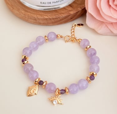 ein Armband mit Rosenquarz und vergoldeten Anhängern