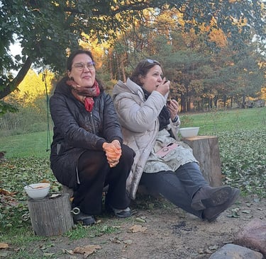two women sitting on a bench in a park
