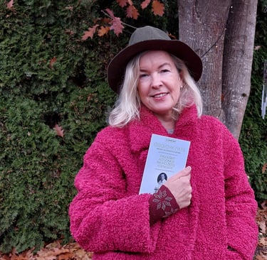 a woman in a pink jacket and hat holding a book