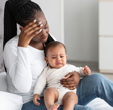 Overwhelmed mother holding her baby, illustrating the struggles of postpartum depression and maternal mental health challenge