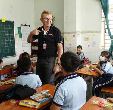 English teacher standing at the front of a classroom in Cambodia
