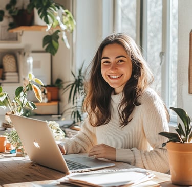 Mujer joven sonríe frente a su laptop en un espacio luminoso, representa emprendimientos digital en un ambiente inspirador.