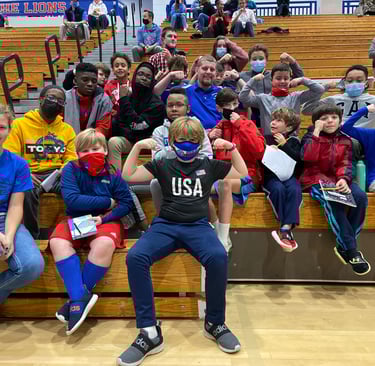 a group of people sitting on a bench with a man in a blue shirt
