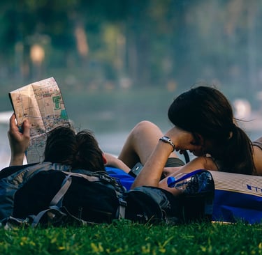 a woman reading a book while sitting on a bench