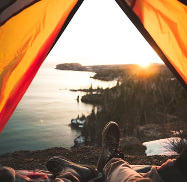 a person sitting in a tent with their feet up