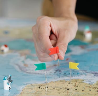 a person holding a pin pinpoint flag on a map of the world