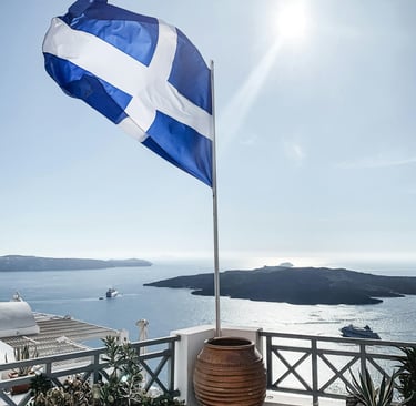 a Greece flag on a balcony with a potted planter