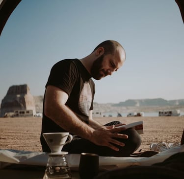 a man sitting in a tent with a laptop