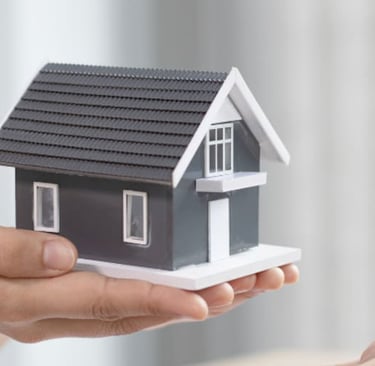 a woman holding a small house model