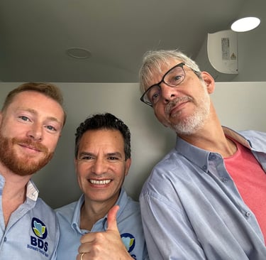 three men standing in a room with thumbs up