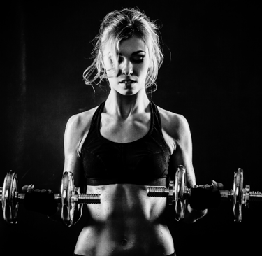 a woman in a sports bra top and a pair of dumbs