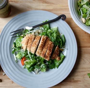 Thai garden salad topped with sliced sesame chicken