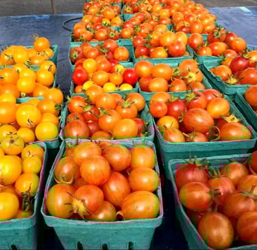 cherry tomatoes in green containers at a market