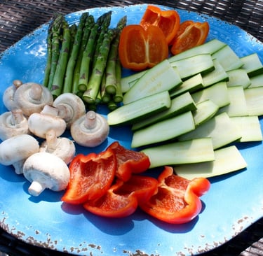 raw and sliced peppers, zucchini, mushrooms and asparagus