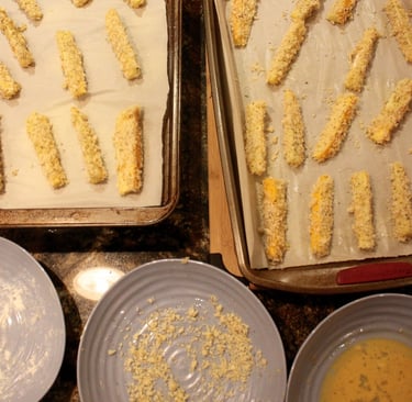 zucchini fingers ready for the oven on cookie sheets