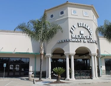a restaurant with a clock tower and palm trees