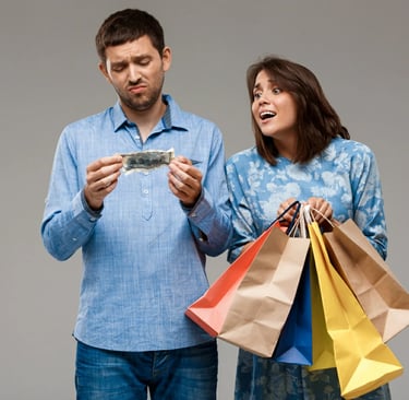 Woman with purchases, man holding last money over grey wall