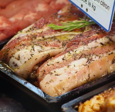 a variety of meats and vegetables in a display case