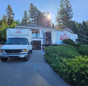 Canada’s Most Wanted Movers trucks loading at a hillside residential property in the Lower Mainland.