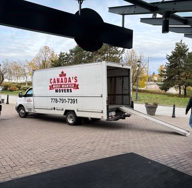 Canada’s Most Wanted Movers unloading at a commercial property in Coquitlam with ramp extended.