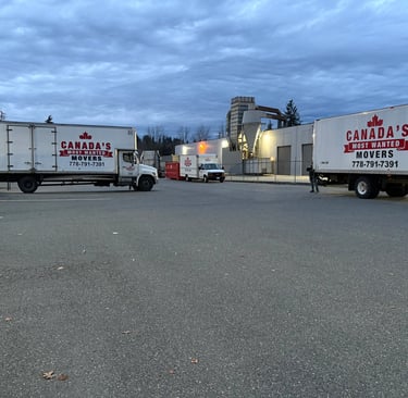 Canada’s Most Wanted Movers trucks parked at an industrial warehouse in Vancouver before a scheduled move.