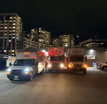 Canada’s Most Wanted Movers trucks lined up for a nighttime move in Vancouver’s residential district.