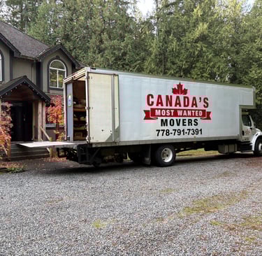 Canada’s Most Wanted Movers truck parked at a forest-side home in the Lower Mainland during a residential move.