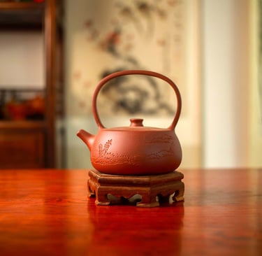 A brown teapot engraved with designs is placed on a wooden stand