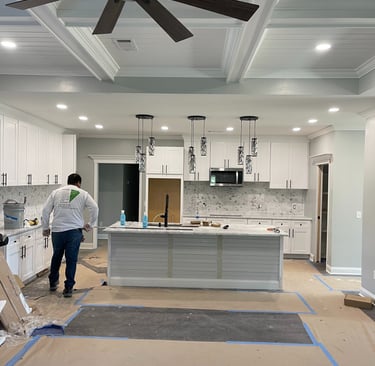 A worker wearing a Garnet Painting shirt working on a kitchen remodel.