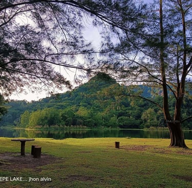 Serene view of Mapanuepe Lake in Zambales with lush green mountains and a peaceful picnic spot, capt