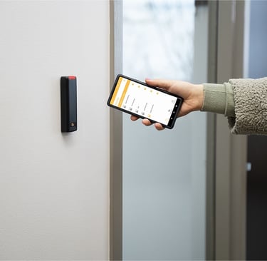 User accessing a secured door using the ProdataKey mobile app with a Bluetooth-enabled reader for cloud-based access control