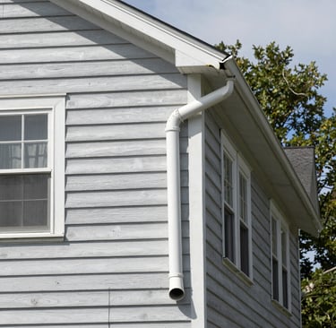 Close-up of a Patriot Roofing and Siding truck parked outside a charming Maine home.