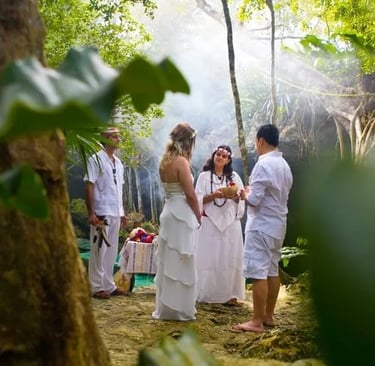 Pareja celebrando una ceremonia de boda maya mística espiritual en un cenote rodeado por la selva maya de la Riviera Maya.