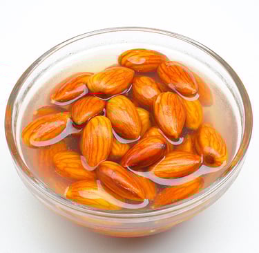 a bowl of almonds soaking in a glass bowl of water