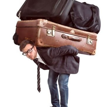 a man carrying too much luggage