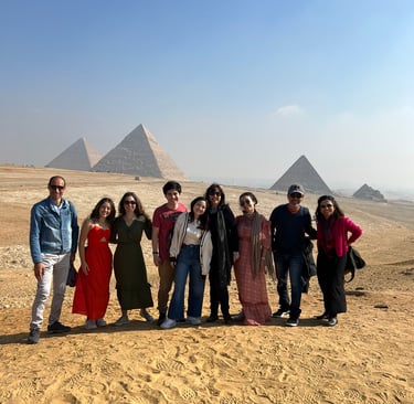 grupo de tuistas com foto panoramica e no fundo aparecem as misteriosas piramides de egito 