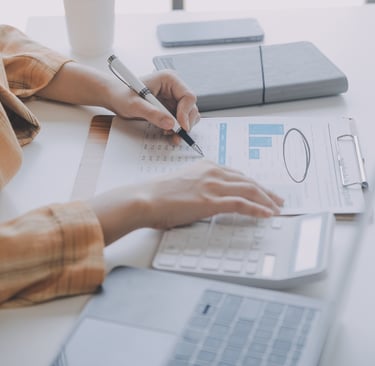 A photo showing the hands of an administrator holding a pencil examining documents