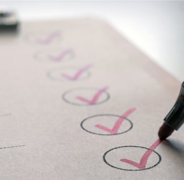 A photo of a checklist and marker showing red checkmarks in each circle of the list 