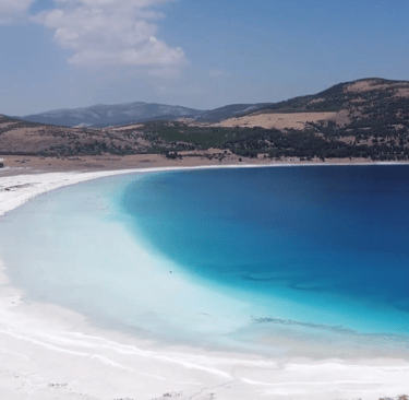 The Lake Salda shores with a blue sky and a hill in the background