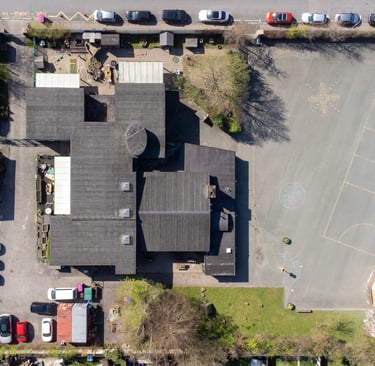 Aerial drone shot of the school from above. You can see the roof and playground.