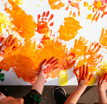 a group of children's hands and hands painted with orange paint