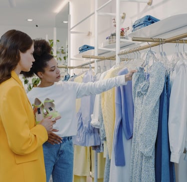 Consultora de imagem auxiliando cliente na escolha de roupas durante uma consultoria de compras.