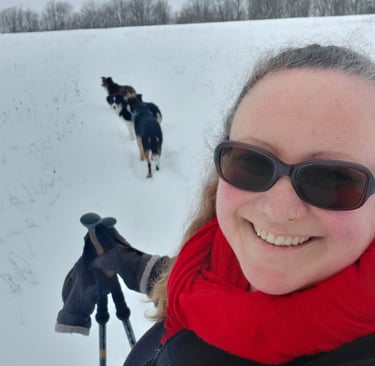 Image of Anne snowshoeing wit dogs. 