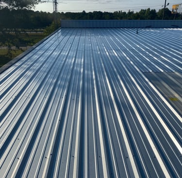 a metal roof with a blue sky and trees